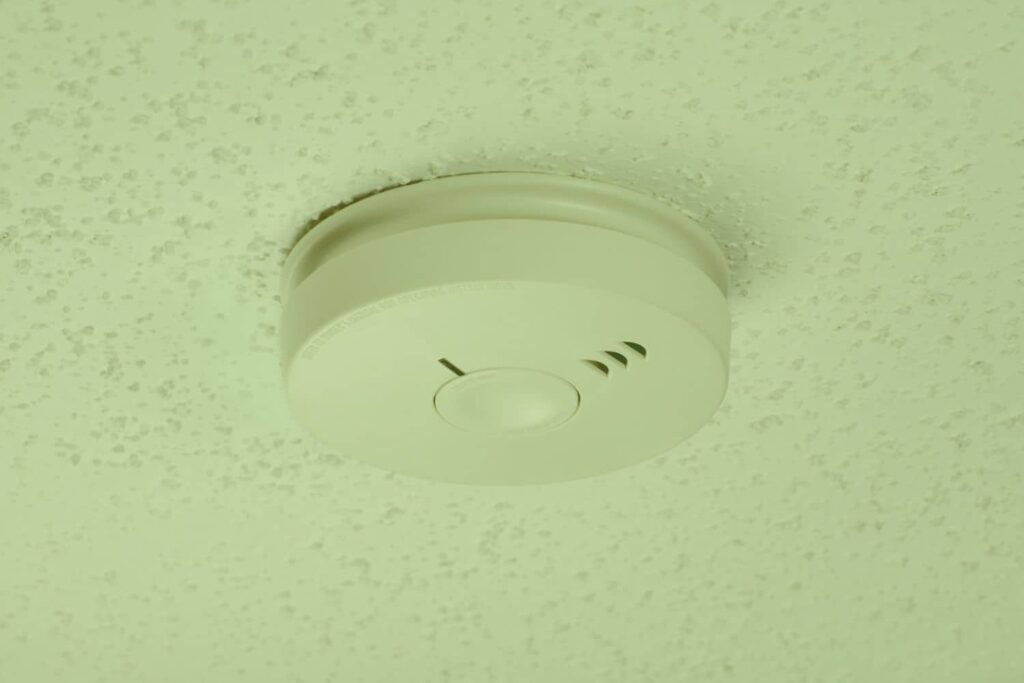 Smoke detector placement shown mounted on a textured ceiling
