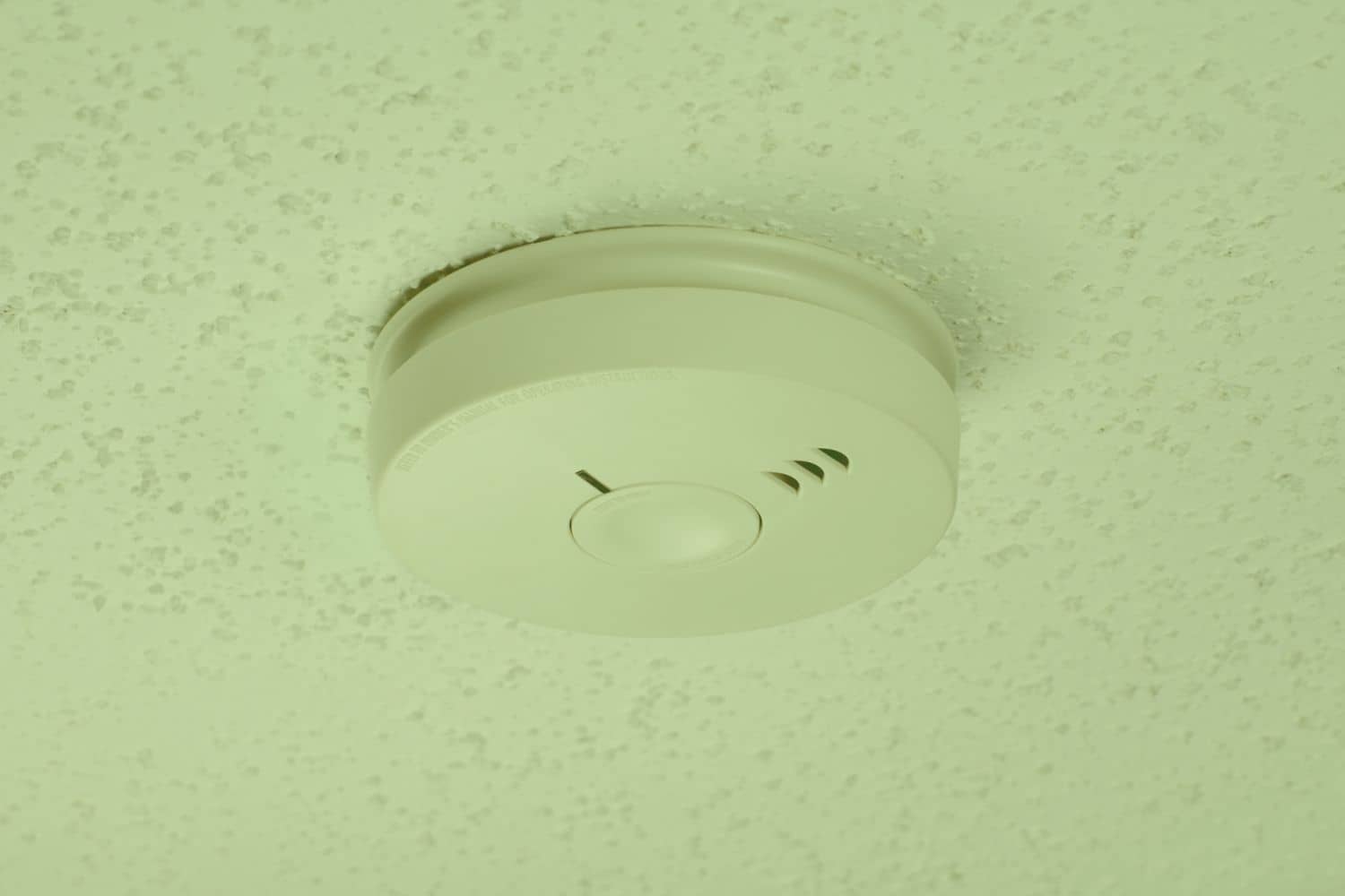 Smoke detector placement shown mounted on a textured ceiling